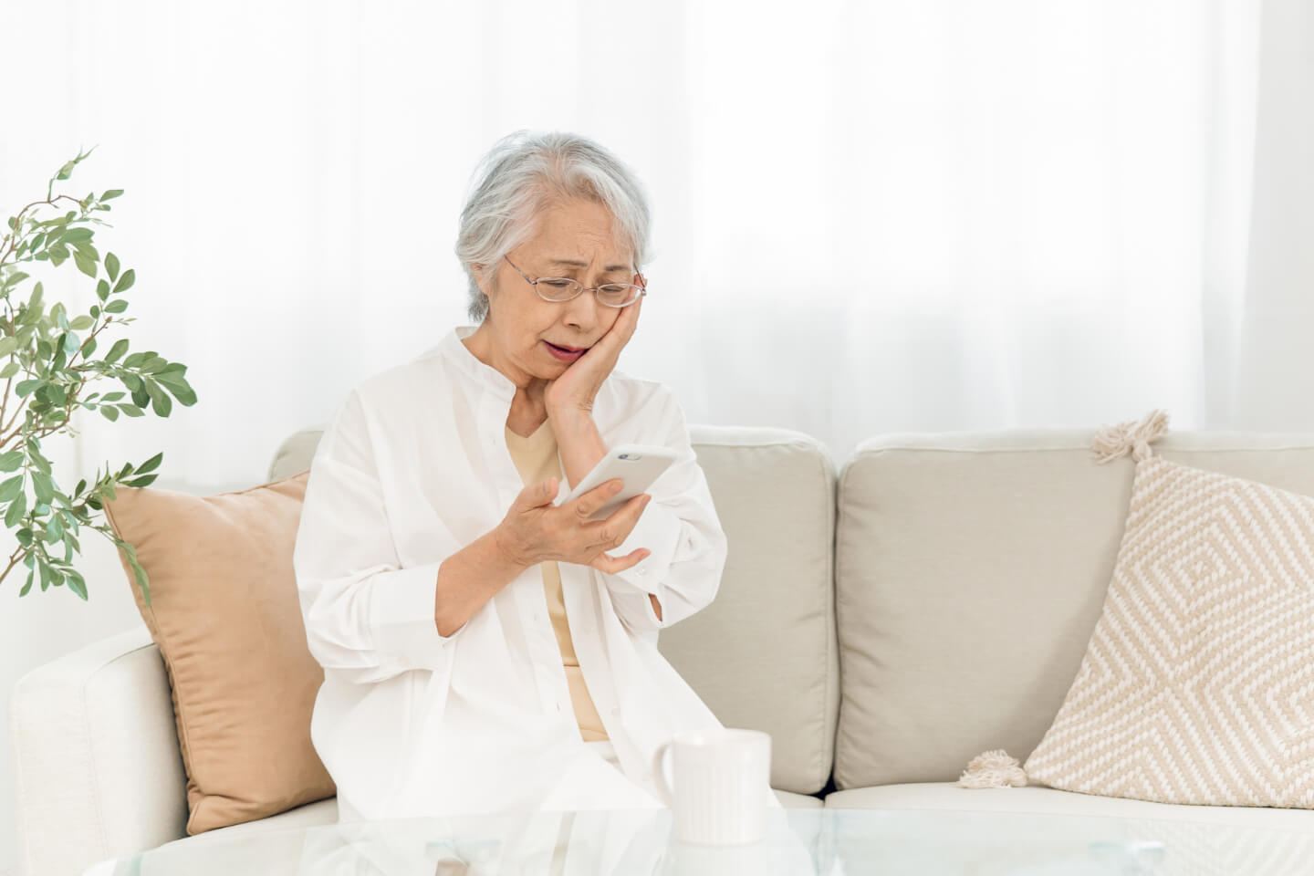 詐欺電話で不安になるシニア女性